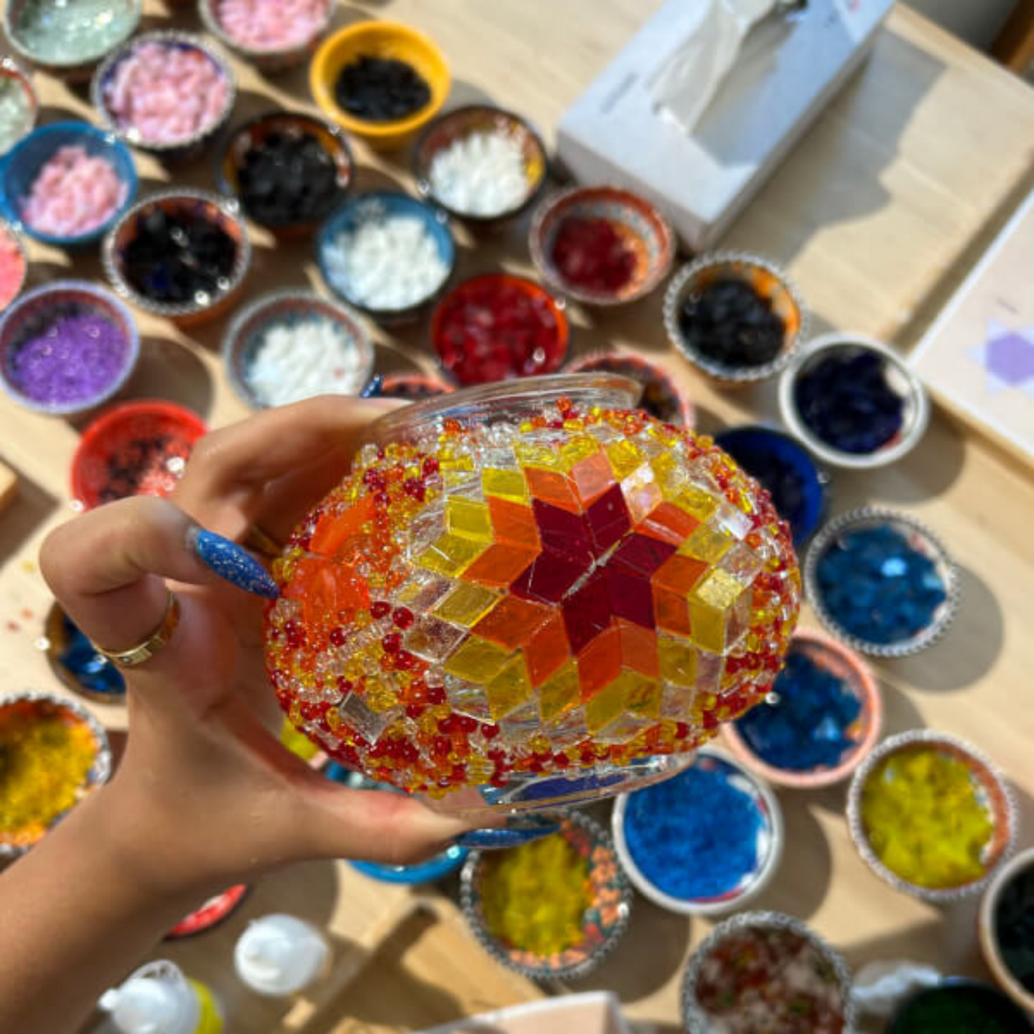 Mosaic lamp glass pieces being placed by hand during the London workshop